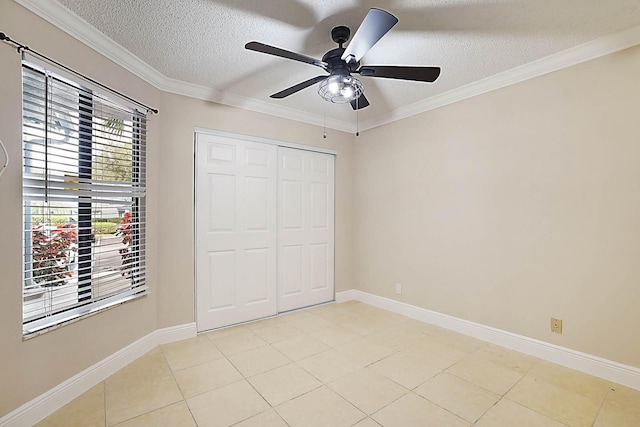 unfurnished bedroom with ceiling fan, ornamental molding, a textured ceiling, light tile patterned flooring, and a closet