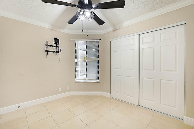 unfurnished bedroom featuring crown molding, ceiling fan, a closet, and a textured ceiling