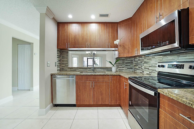 kitchen with light stone counters, stainless steel appliances, and light tile patterned floors