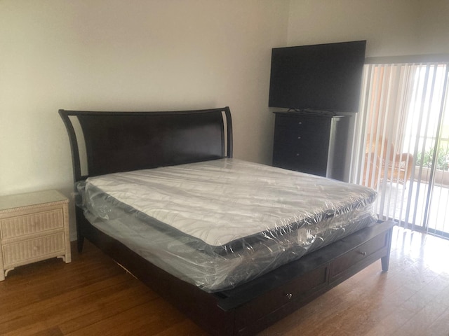 bedroom featuring hardwood / wood-style floors and access to outside