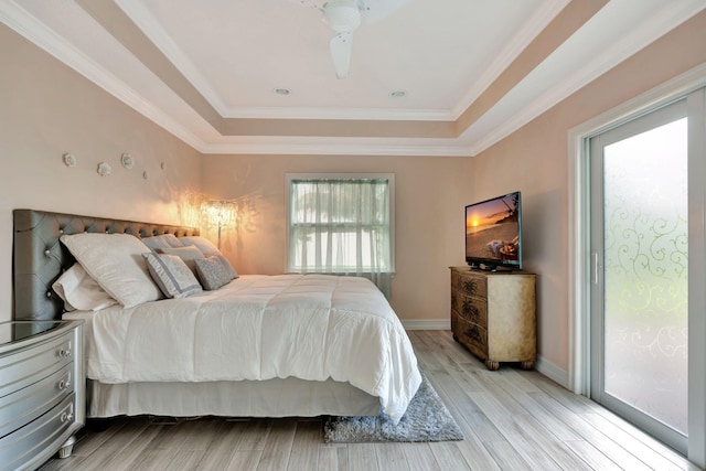 bedroom featuring multiple windows, a tray ceiling, and ceiling fan