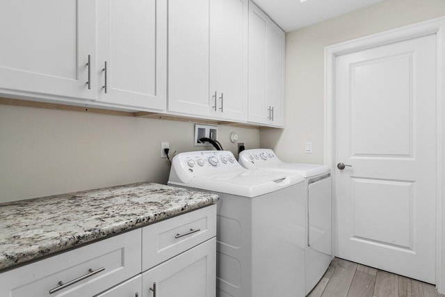 laundry room featuring cabinets and washing machine and clothes dryer