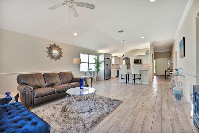 living room featuring light hardwood / wood-style floors, vaulted ceiling, ceiling fan, and ornamental molding