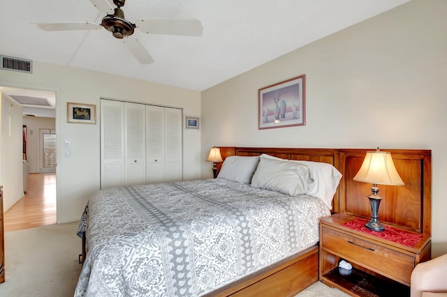 bedroom with ceiling fan, a closet, and light carpet