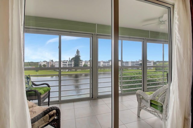 sunroom / solarium featuring a water view, ceiling fan, and a wealth of natural light