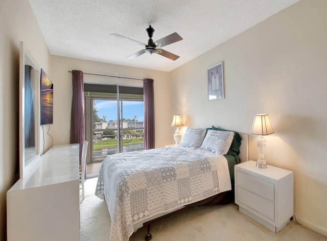 carpeted bedroom featuring a textured ceiling and ceiling fan