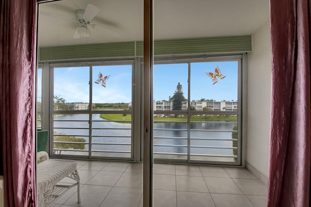 interior space featuring ceiling fan, a water view, and a healthy amount of sunlight