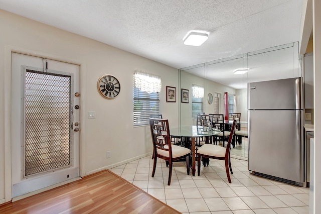 dining area featuring a textured ceiling and light tile patterned floors