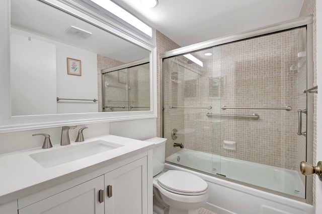 full bathroom with toilet, vanity, and shower / bath combination with glass door