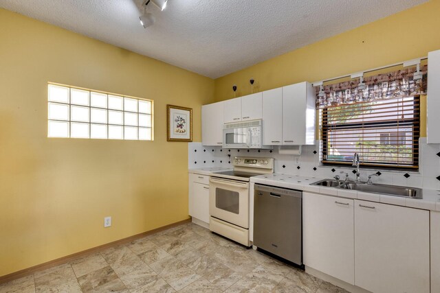 kitchen featuring sink, white cabinetry, tasteful backsplash, a textured ceiling, and white appliances