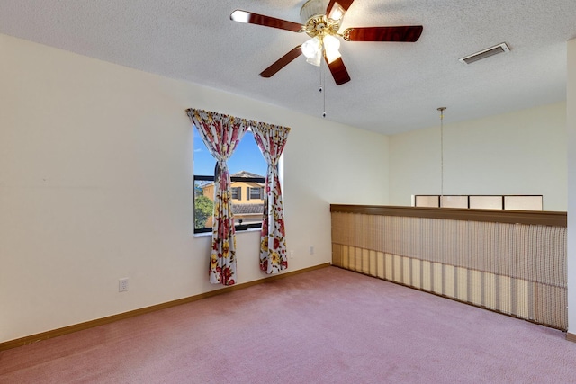 spare room with ceiling fan, a textured ceiling, and carpet flooring