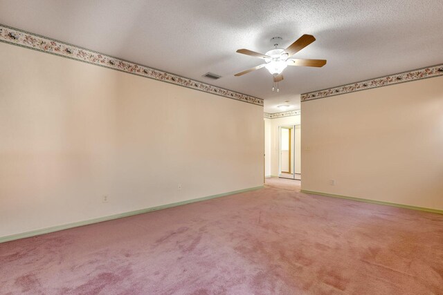 carpeted empty room with ceiling fan and a textured ceiling