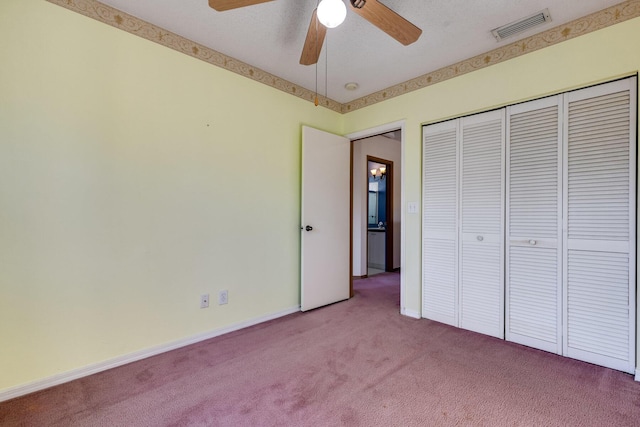 unfurnished bedroom featuring ceiling fan, carpet floors, a closet, and a textured ceiling