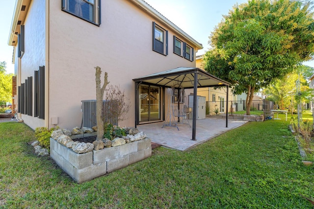 rear view of house featuring a yard, a gazebo, a patio area, and central AC unit