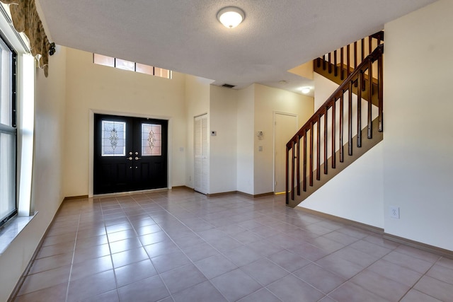 foyer entrance featuring light tile patterned floors and a textured ceiling