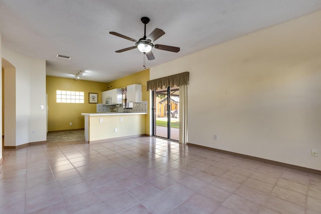 unfurnished living room with ceiling fan and light tile patterned floors