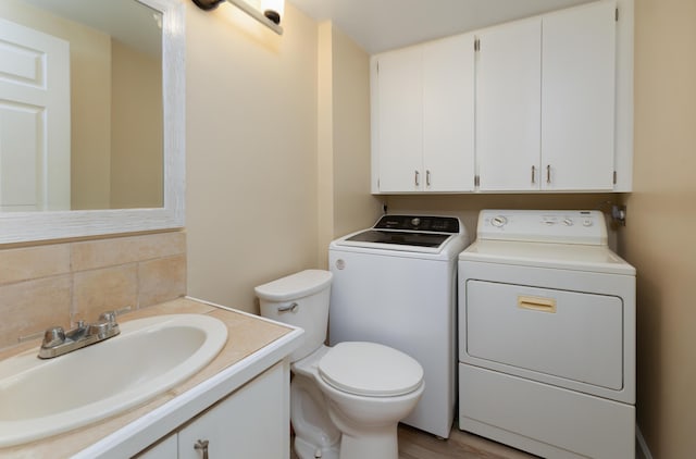 bathroom with vanity, tasteful backsplash, toilet, and washing machine and clothes dryer