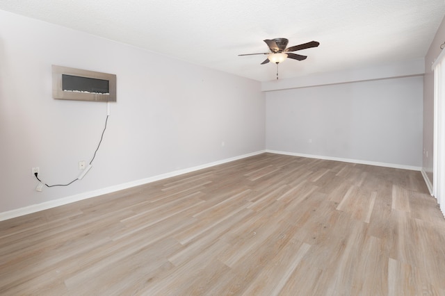 empty room with ceiling fan and light wood-type flooring