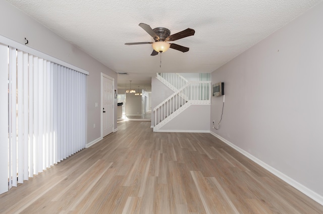 unfurnished living room featuring ceiling fan, light hardwood / wood-style floors, and a textured ceiling