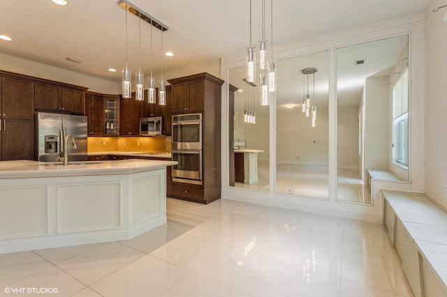 kitchen featuring appliances with stainless steel finishes, a sink, recessed lighting, pendant lighting, and light tile patterned floors