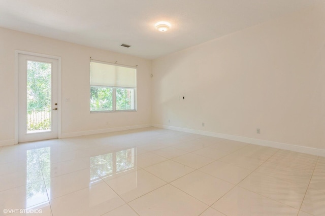 empty room featuring light tile patterned floors and baseboards