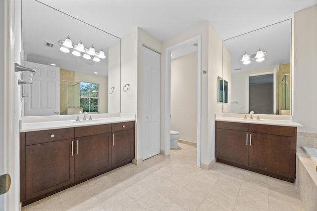 bathroom with tile patterned flooring, vanity, toilet, and an enclosed shower