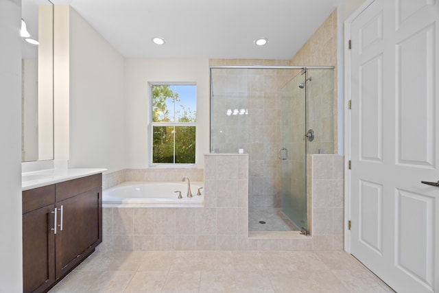 bathroom with tile patterned floors, vanity, and shower with separate bathtub