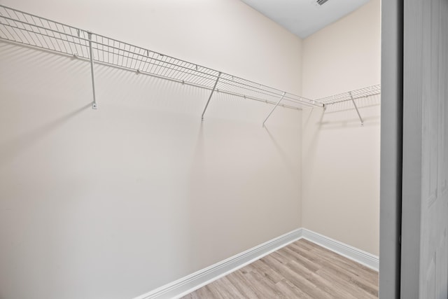 walk in closet with hardwood / wood-style flooring