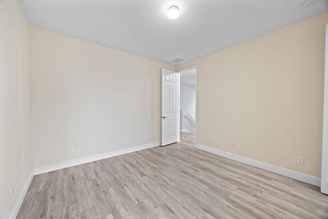 empty room with light wood-type flooring and baseboards