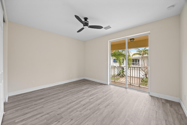 empty room with wood finished floors, a smoke detector, a ceiling fan, and baseboards