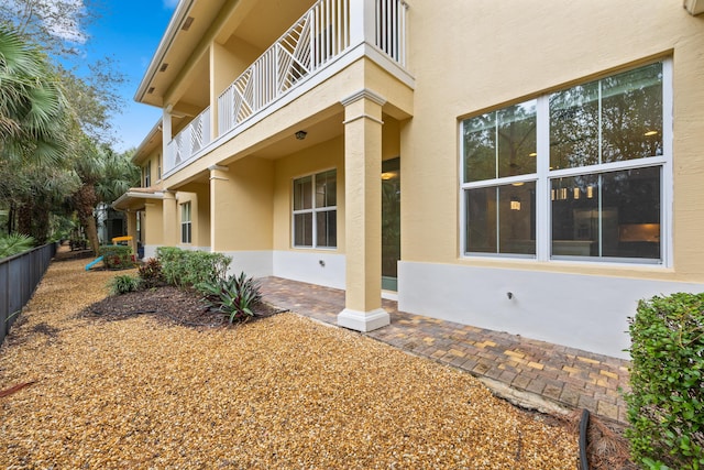 view of side of property featuring stucco siding and a balcony