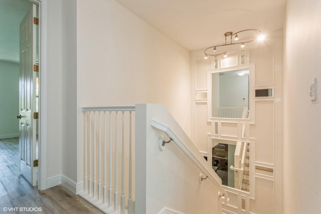 staircase featuring wood finished floors and baseboards