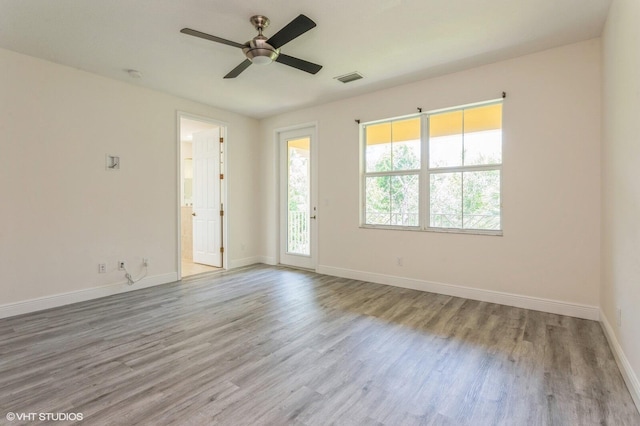 empty room featuring wood finished floors, baseboards, and a ceiling fan