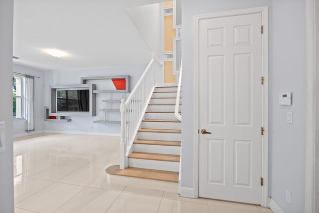 unfurnished living room with sink and light tile patterned floors