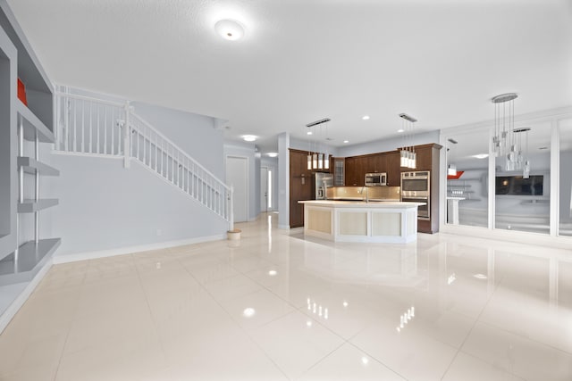 unfurnished living room featuring sink and light tile patterned floors