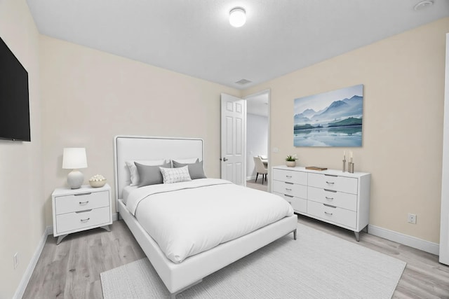 bedroom with baseboards and light wood-type flooring