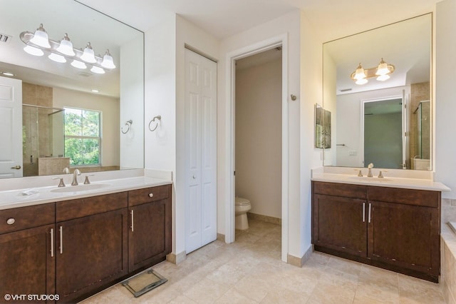 full bath featuring two vanities, a stall shower, toilet, and a closet