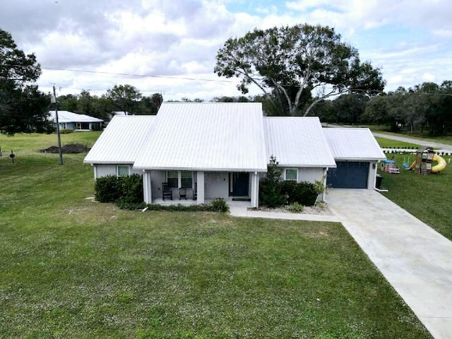 ranch-style home featuring a garage, covered porch, and a front lawn