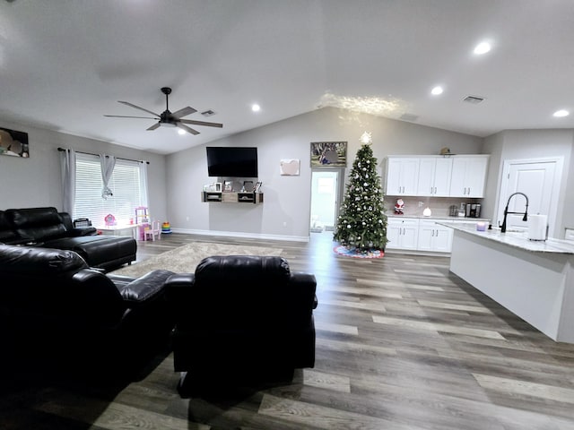 living room with ceiling fan, light hardwood / wood-style floors, and lofted ceiling