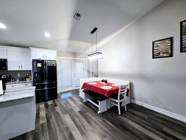 dining room with dark hardwood / wood-style floors, lofted ceiling, a textured ceiling, and french doors