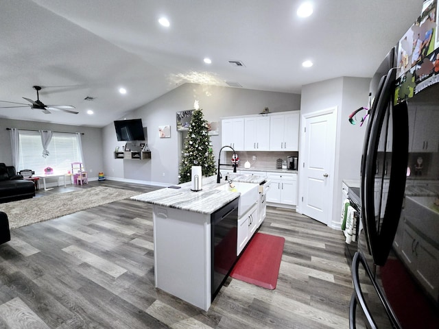 kitchen featuring tasteful backsplash, ceiling fan, sink, white cabinets, and an island with sink