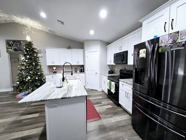 kitchen featuring black appliances, backsplash, white cabinetry, and a kitchen island with sink