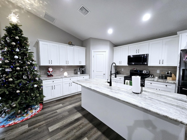 kitchen with light stone countertops, tasteful backsplash, vaulted ceiling, electric range, and white cabinets