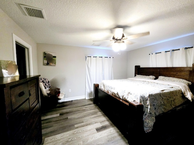 bedroom featuring hardwood / wood-style floors, a textured ceiling, and ceiling fan