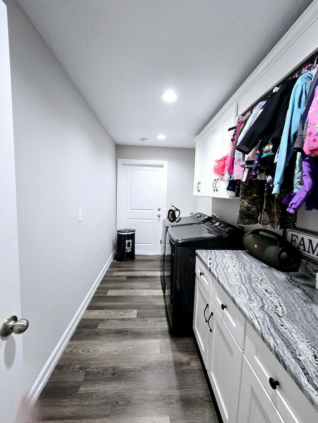 clothes washing area with dark hardwood / wood-style flooring, cabinets, and independent washer and dryer