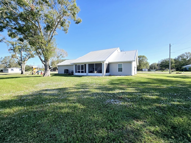 back of property featuring a lawn and a sunroom