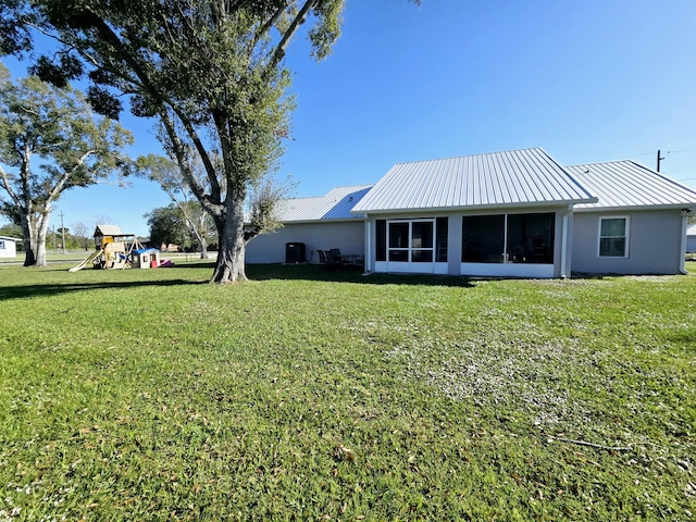 view of yard featuring a playground and a sunroom