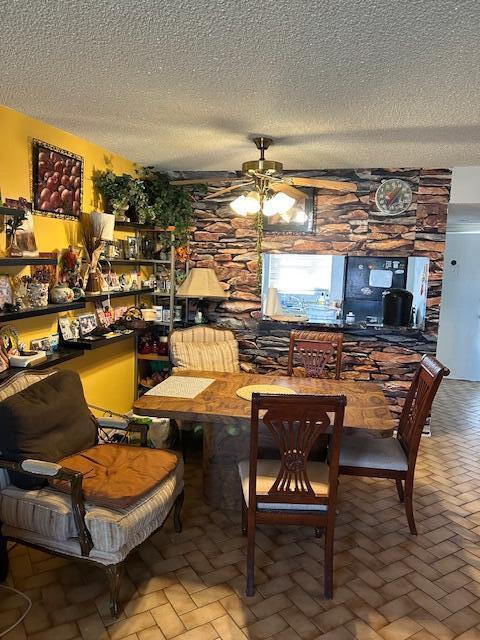 dining room with ceiling fan and a textured ceiling