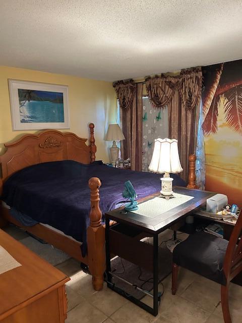 bedroom with light tile patterned floors and a textured ceiling