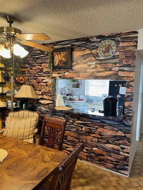 bar with a textured ceiling and ceiling fan